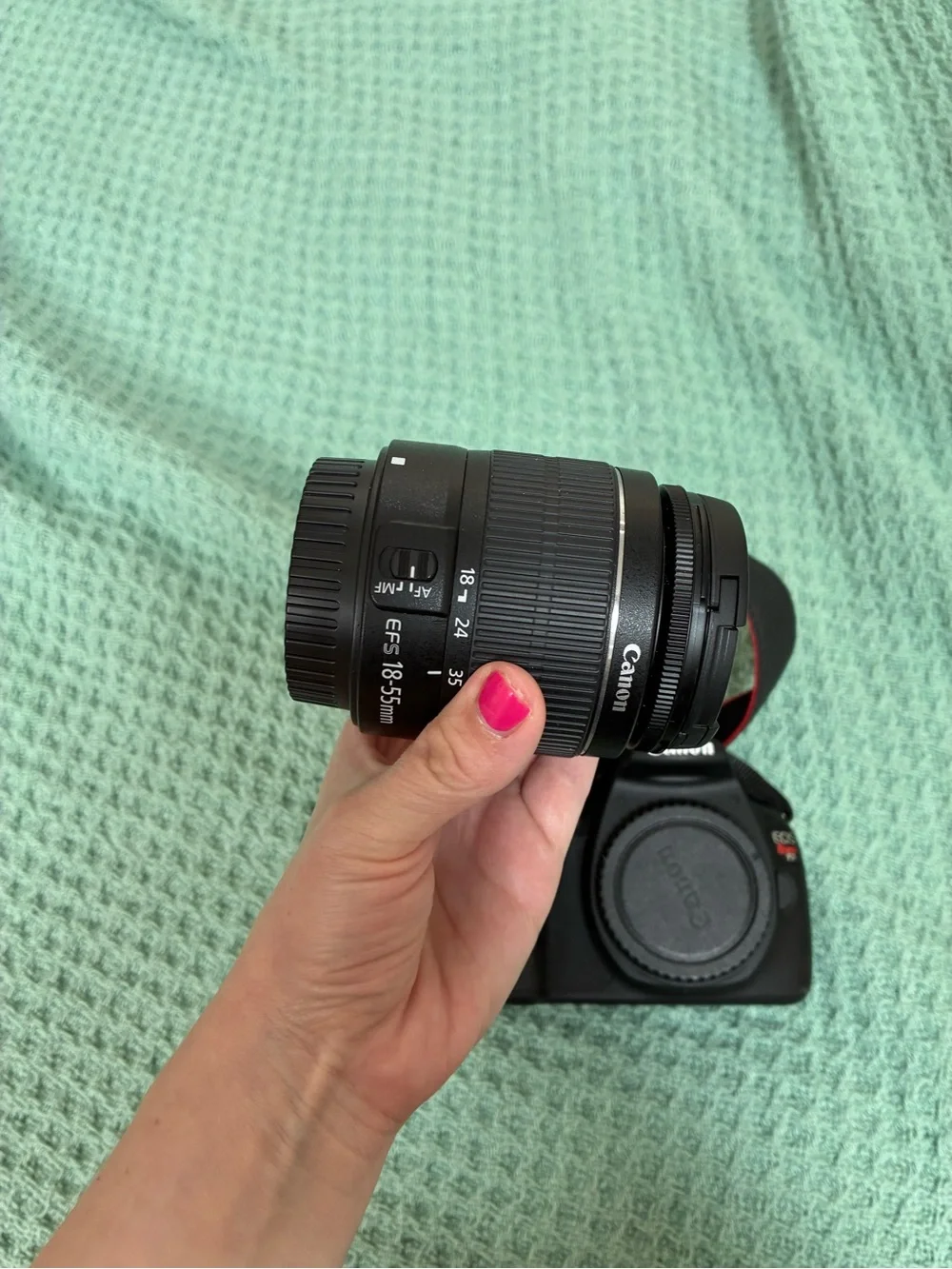 Canon DSLR Camera Body in Black with Red Strap Accents and kit lens.